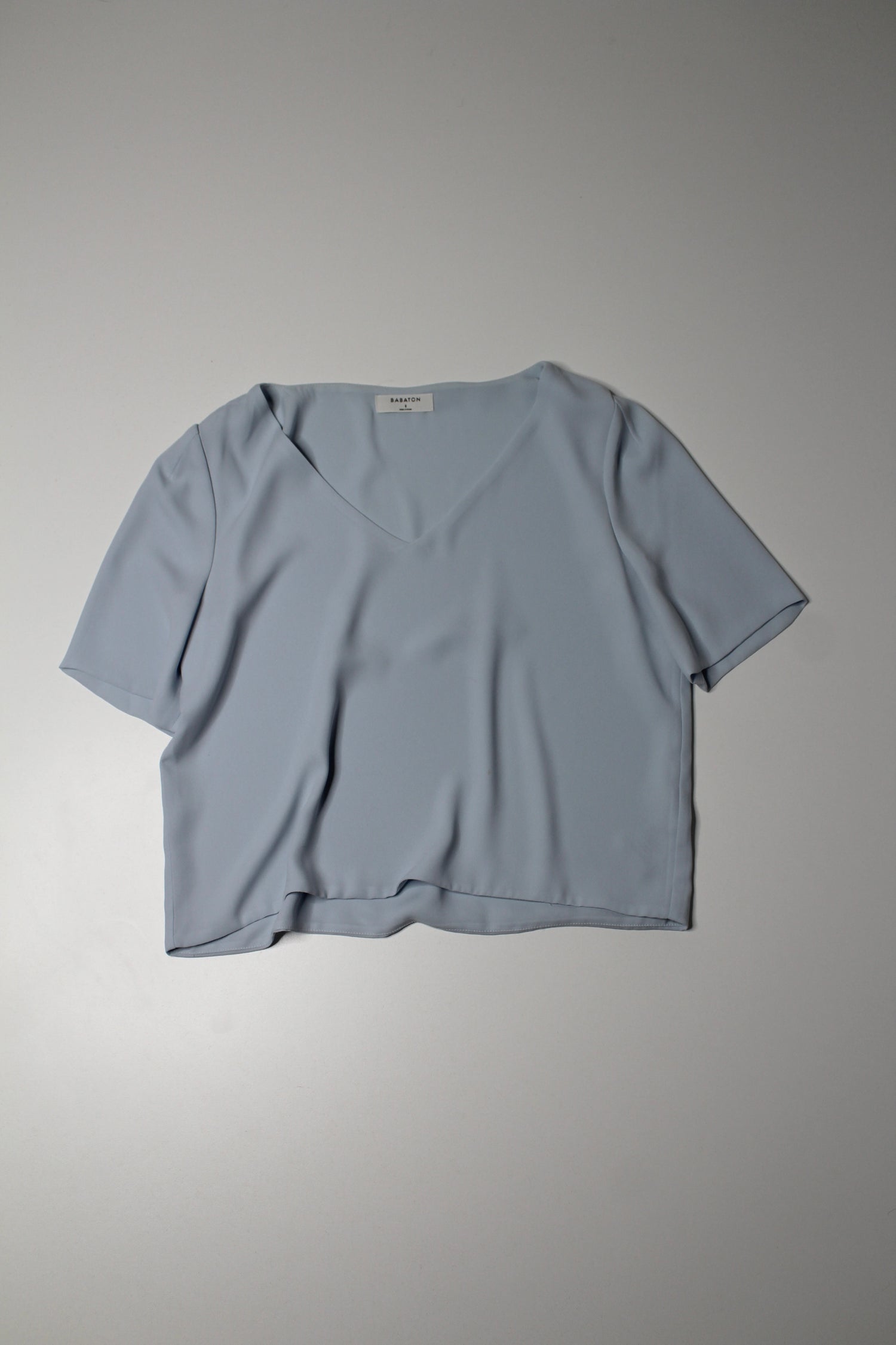 A light blue, short-sleeved, V-neck blouse by Aritzia